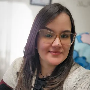 kathy is has long dark hair and is wearing glasses